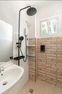 杜馬格特的住宿－E and C tourist inn，带淋浴和白色盥洗盆的浴室