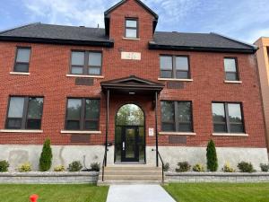 a red brick house with a black door at Cozy Maison Apt #4 in Gatineau