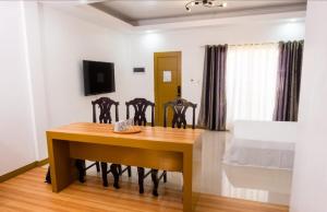a dining room with a table and chairs and a bed at E and C tourist inn in Dumaguete
