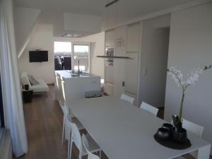 紐波特的住宿－Apartment Neoportus III with roof terrace，白色的厨房配有长白色的桌子和椅子