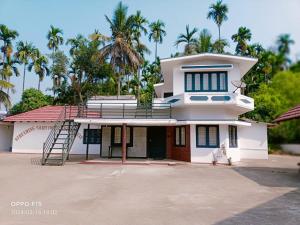 una casa blanca con un perro sentado frente a ella en Streaming Valley Coffee Estate Stay en Madikeri