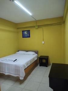 um quarto com uma cama numa parede amarela em NovHotel em Comalcalco