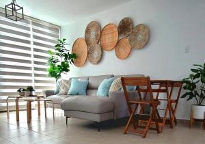 een woonkamer met een bank en houten borden aan de muur bij 6-Person BeachFront/Pool Apt at Isabela, PR in Isabela