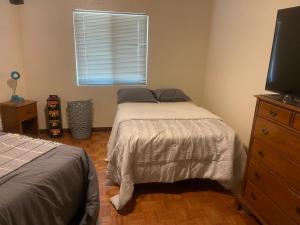 een slaapkamer met 2 bedden, een televisie en een raam bij Horseman Lodge in Mesa
