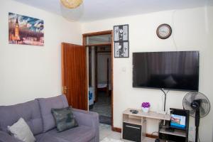 a living room with a couch and a flat screen tv at AriBri Apartment, Bungoma Town. in Bungoma