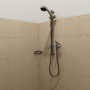 a shower with a shower head in a bathroom at KENEWAE LIVING in Wonosari