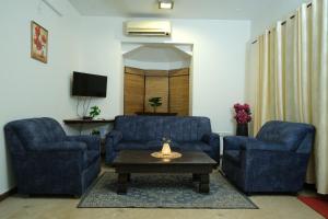 a living room with two blue chairs and a coffee table at 2 BHK beach goan villa with pool calangute in Calangute