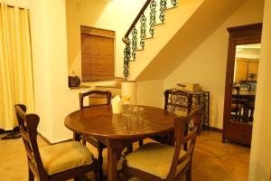 a dining room with a wooden table and chairs at 2 BHK beach goan villa with pool calangute in Calangute