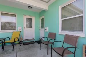 um quarto com cadeiras, uma porta e janelas em Captain's Quarters - Weekly Rental apts em Clearwater Beach