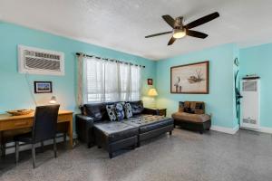 ein Wohnzimmer mit blauen Wänden und einem Deckenventilator in der Unterkunft Captain's Quarters - Weekly Rental apts in Clearwater Beach