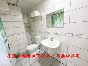 a bathroom with a toilet and a sink at My House Hotel in Luodong