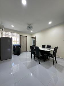 a dining room with a table and black chairs at Penampang Delima House in Kota Kinabalu