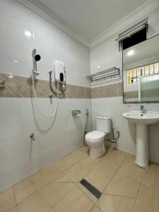a bathroom with a shower and a toilet and a sink at Penampang Delima House in Kota Kinabalu