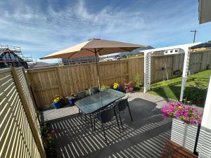 a patio with an umbrella and a table and chairs at Studio on Patete in Taupo