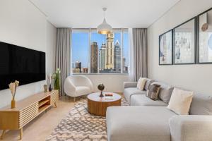 a living room with a couch and a tv at DIFC 1BR at SkyGardens Tower in Dubai