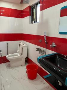 a bathroom with a toilet and a sink at Hotel Anurag Palace in Agartala