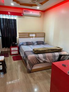 1 dormitorio con 1 cama grande y pared roja en Hotel Anurag Palace en Agartala