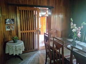 ein Esszimmer mit einem Tisch, Stühlen und einer Tür in der Unterkunft Maliga Inn in Gampola