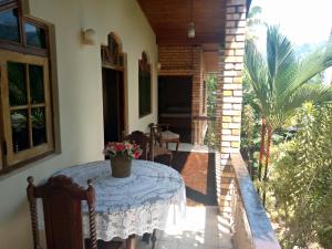 eine Veranda mit einem Tisch und einer Blumenvase darauf in der Unterkunft Maliga Inn in Gampola