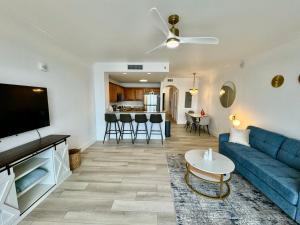 ein Wohnzimmer mit einem blauen Sofa und einem TV in der Unterkunft Balcony King Suite - Lake & Pool view in Orlando