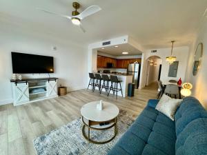 ein Wohnzimmer mit einem blauen Sofa und einem Tisch in der Unterkunft Balcony King Suite - Lake & Pool view in Orlando