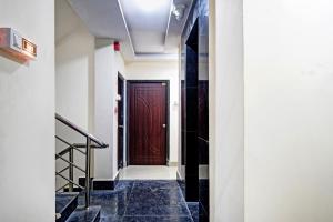 a hallway with a brown door and stairs at OYO Flagship Aarvi Palace in Cuttack