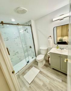 a bathroom with a shower and a toilet and a sink at Balcony King Suite - Lake & Pool view in Orlando