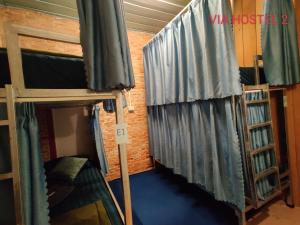 a room with two bunk beds and a curtain at Via Pakse Hostel & Cafe in Pakse