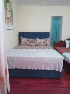Trinish homestay في هاتون: سرير مع اللوح الأمامي الأزرق في الغرفة