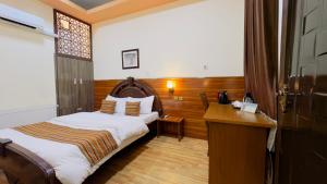 Cette chambre comprend un lit et un bureau. dans l'établissement Khyber Hotel, à Kaboul