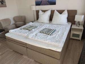 een bed met twee kussens in een kamer bij Wohnung Sonnenschein inkl Strandkorb vom 01 05-01 10 in Grömitz