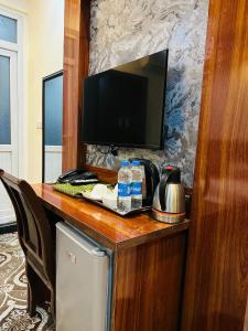 a desk with a television and water bottles on it at Khyber Hotel in Kabul