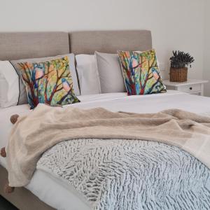a bed with a blanket and pillows on it at Canyonleigh Retreat in Canyonleigh