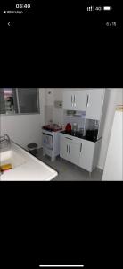 a kitchen with white cabinets and a sink at Apartamento MRV perto da musiva in Várzea Grande