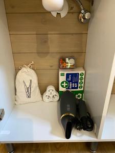 a shelf in a room with a bag and a hair dryer at La Tiny House de Nanou in Rochefort