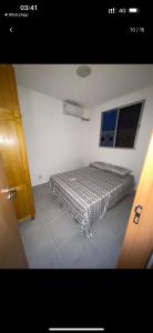 a bedroom with a bed in the corner of a room at Apartamento MRV perto da musiva in Várzea Grande