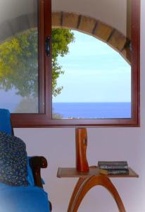 a window in a room with a chair and a table at Sea-Blended Nature House in Ayia Trias