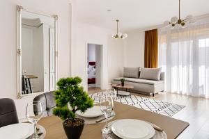 a living room with a table and a couch at Sika Imperial Garden Apartment - cazare Arad - self check-in in Arad