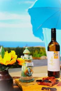 a bottle of wine sitting next to a vase with flowers at Sea-Blended Nature House in Ayia Trias