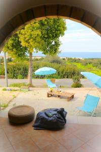 a patio with two chairs and a table and umbrellas at Sea-Blended Nature House in Ayia Trias