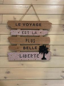 a wooden sign hanging on a wall at La Tiny House de Nanou in Rochefort