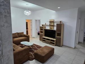 uma sala de estar com um sofá e uma televisão de ecrã plano em Appartement haut standing a la cité attaya em Dakar