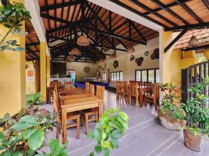 um restaurante com mesas de madeira, cadeiras e plantas em Ninila Villa Phu Quoc em Phu Quoc