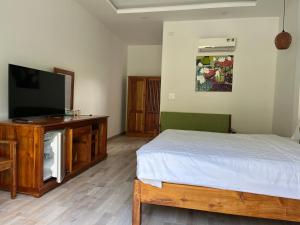 a bedroom with a bed and a flat screen tv at Ninila Villa Phu Quoc in Phu Quoc