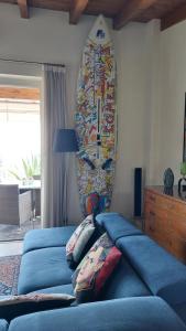 デセンツァーノ・デル・ガルダにあるVilla Paolaのベッドルーム1室(青いベッド2台、壁にサーフボード付)