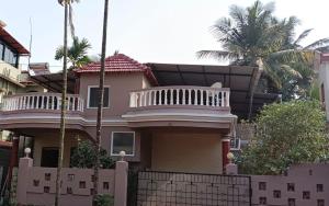 a house with a fence in front of it at Suburbs Holiday Home in Dabolim