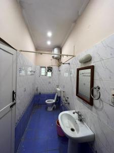 a bathroom with a sink and a toilet at Varal Mane in Bangalore