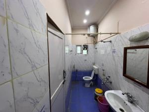 a small bathroom with a toilet and a sink at Varal Mane in Bangalore