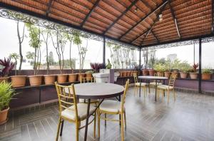 a patio with tables and chairs and plants at PRIME SUITES in Bangalore