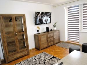 a room with a wooden cabinet and a tv on the wall at Large holiday apartment with a garden in Stepnica in Stepnica